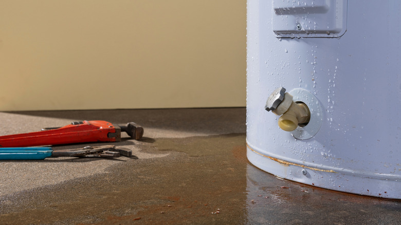 Water heater leak on floor with tools