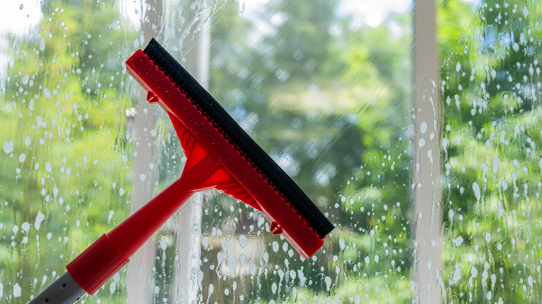 Person cleaning windows to remove dirt and debris