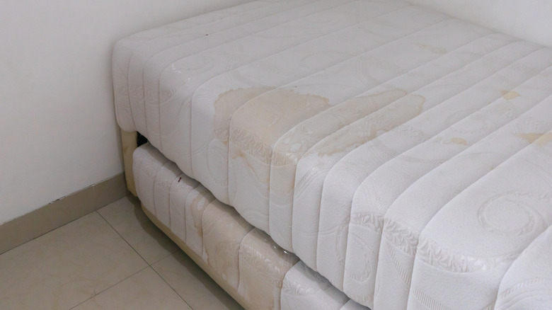 Old, stained mattress in corner of the room