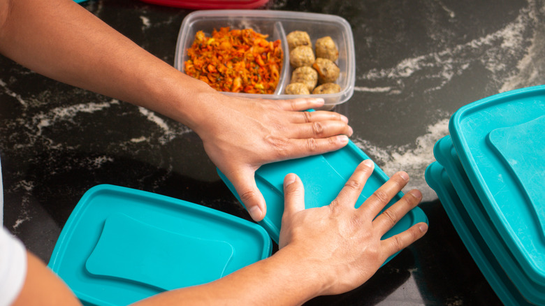 Hand sealing the lids of food-filled containers