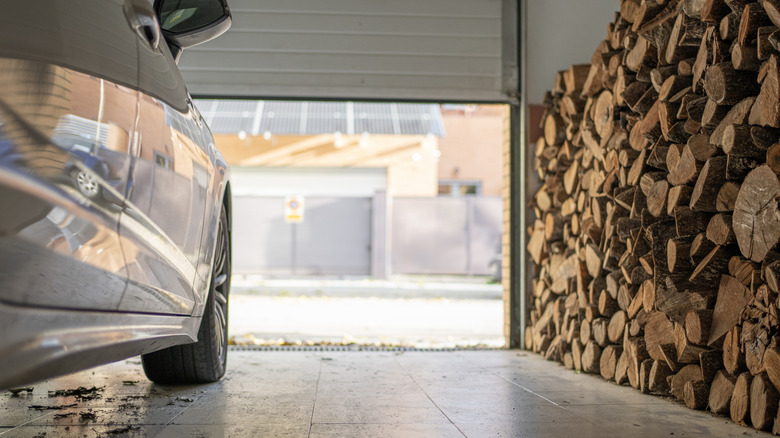 sun coming through garage door and hitting car and pile of firewood