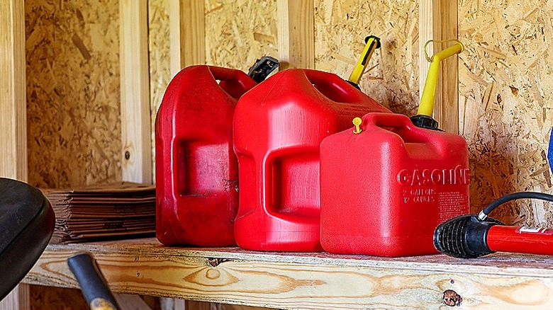 Gasoline canisters on a shelf in a shed