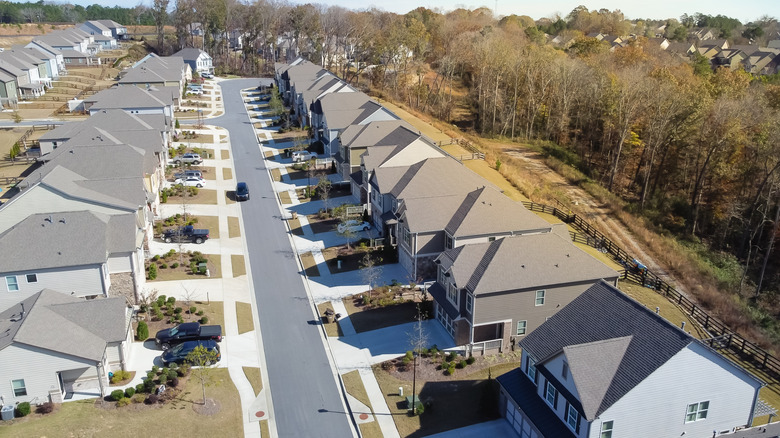 Aerial view clean HOA neighborhood residential streets parked car and front garage homes in new development subdivision outside Atlanta, Georgia.