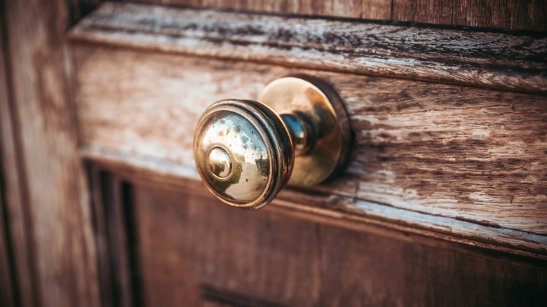 A wooden door features a centrally-placed doorknob