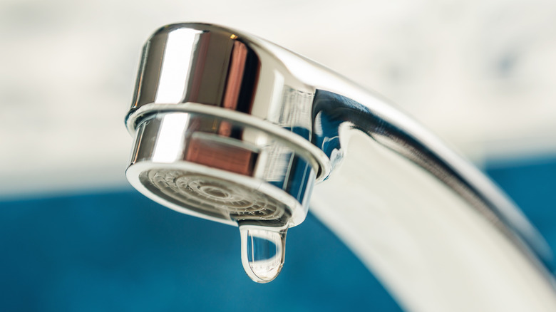 Closeup of chrome faucet dripping