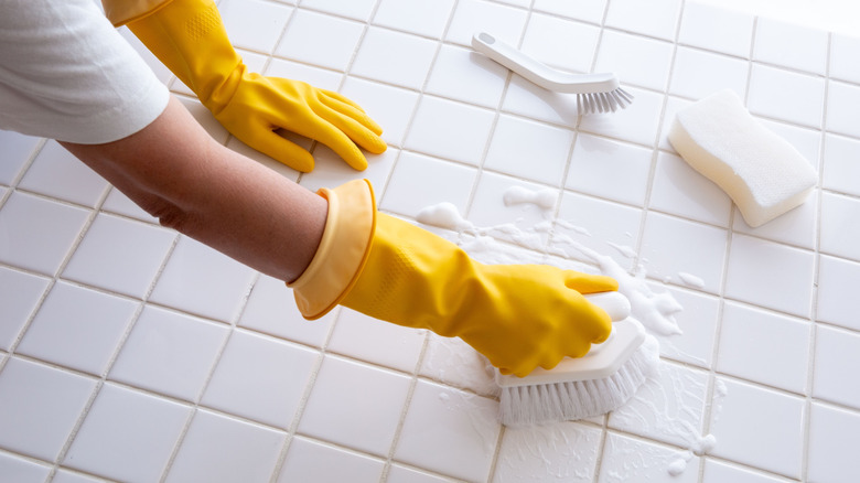 cleaning tiled floor with sponge and soap