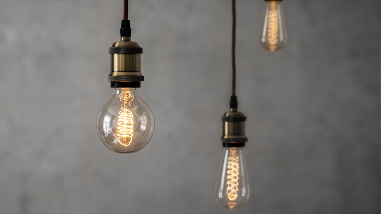 Three vintage style Art Deco faux Edison bulbs on dark pendant cords