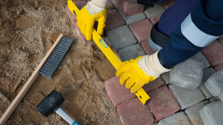 Person fixing patio pavers
