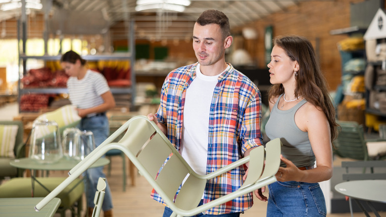 couple in store examining patio chair
