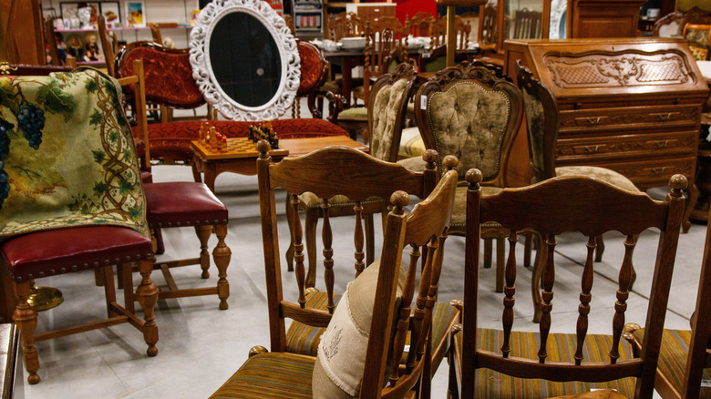 antique chairs, mirror, and dresser in a thrift shop