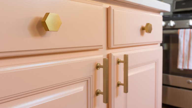 Gold hardware on pink cabinets