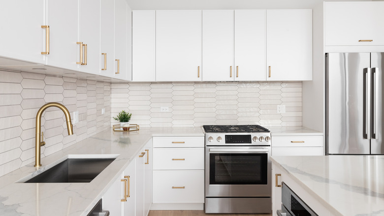 White kitchen with gold hardware and faucet