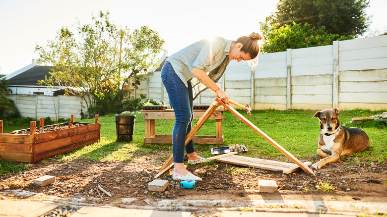 Materials for building a new garden bed next to a completed one full of soil
