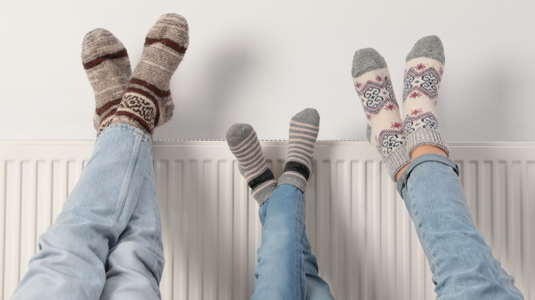 Family in socks resting feet on radiator