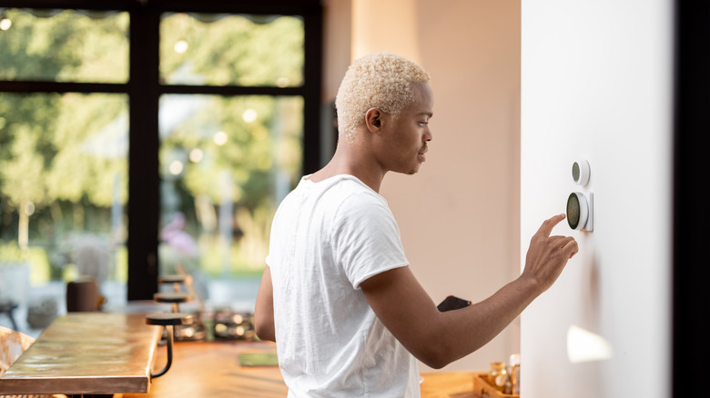 person with thermostat