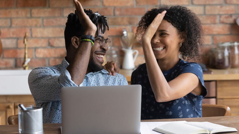 People high-fiving over computer