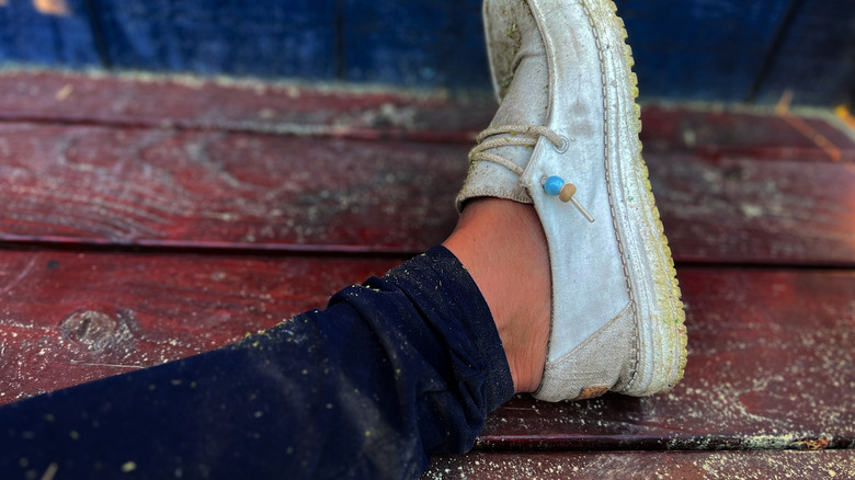 Pant leg and shoe covered with pollen on deck