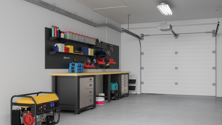 Workshop area in a garage with cabinets, a work surface, and open shelves on the wall