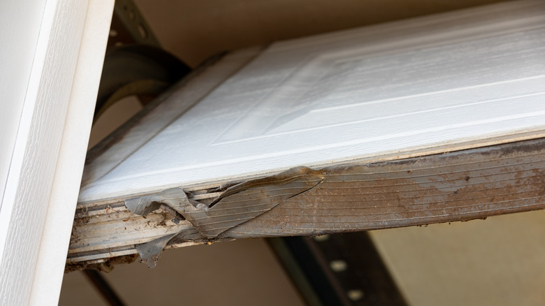 Opened garage door with weatherstripping that's damaged and torn
