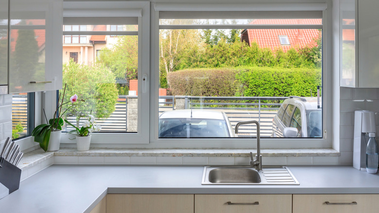 Modern kitchen with large windows by the sink.