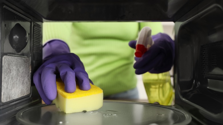 Cleaning microwave oven in kitchen