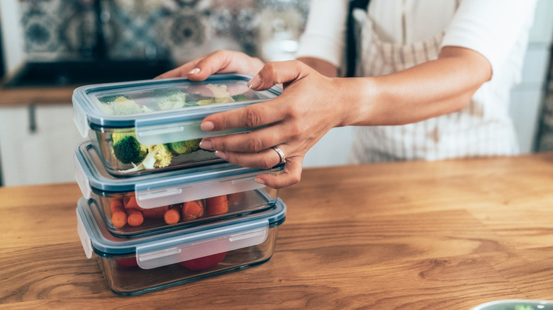 hands stacking glass food containers