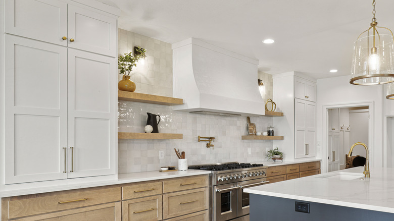 Luxe modern kitchen with light colors, a large island, and tall custom cabinets.