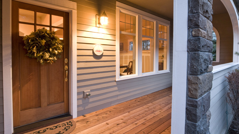 Cozy home with a wooden floor and door, softly lit by a warm porch light at night