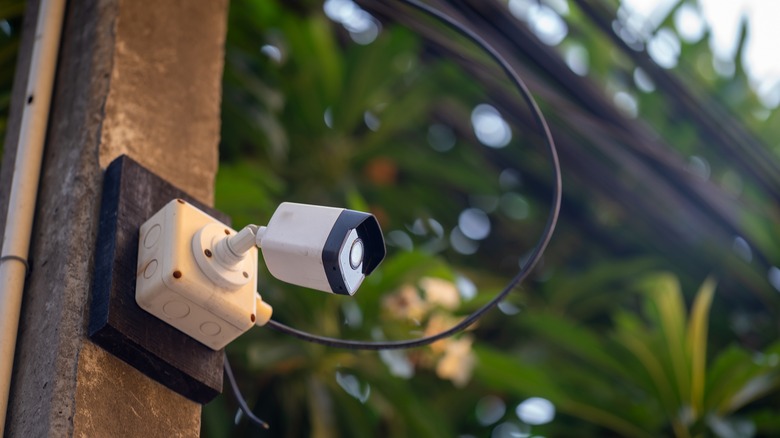 An outdoor security camera mounted on a concrete post