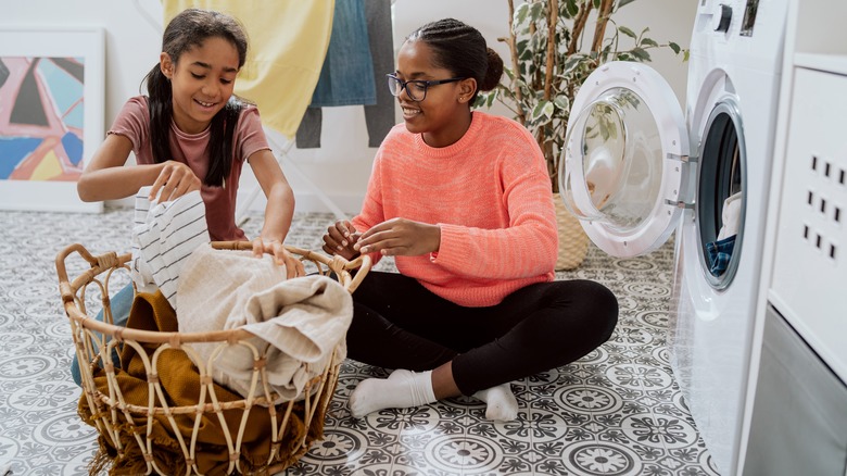 mother and daughter folding laundry