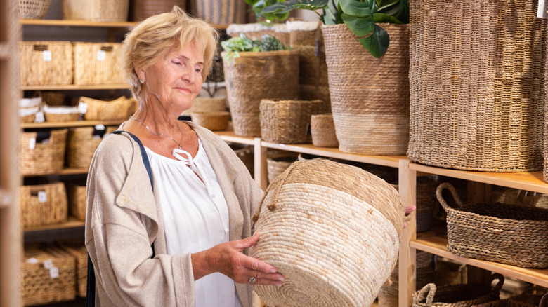 Woman admiring woven basket in a store