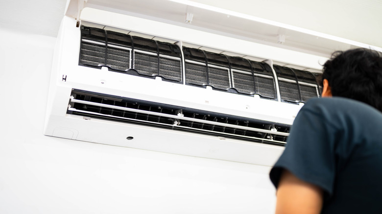 HVAC technician performing air conditioner maintenance inspection