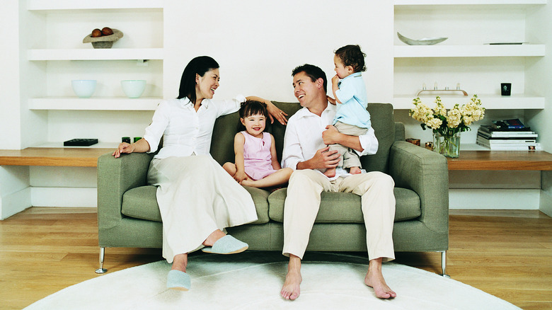 family sitting on green couch