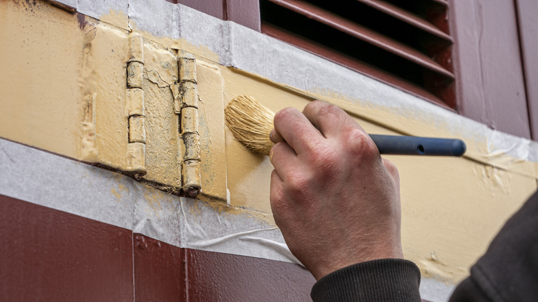 Someone painting door hinge