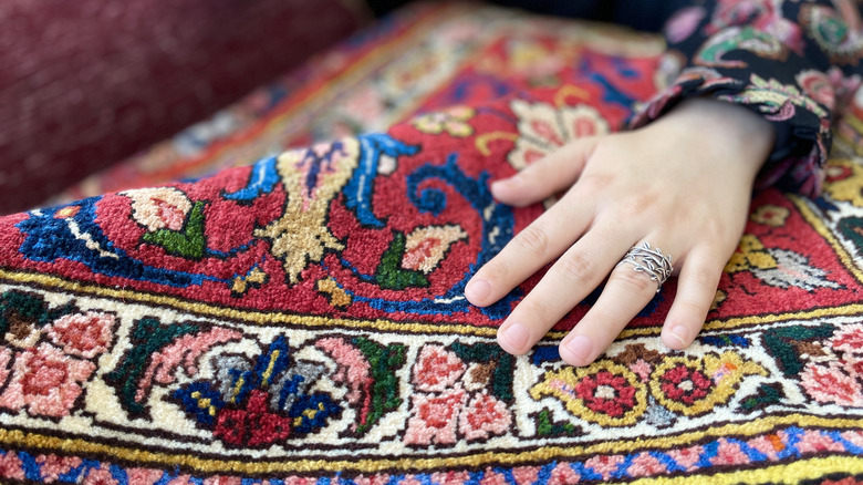 Woman touching a bright-colored rug