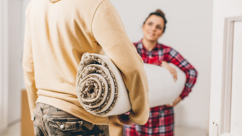 couple throwing out old carpet