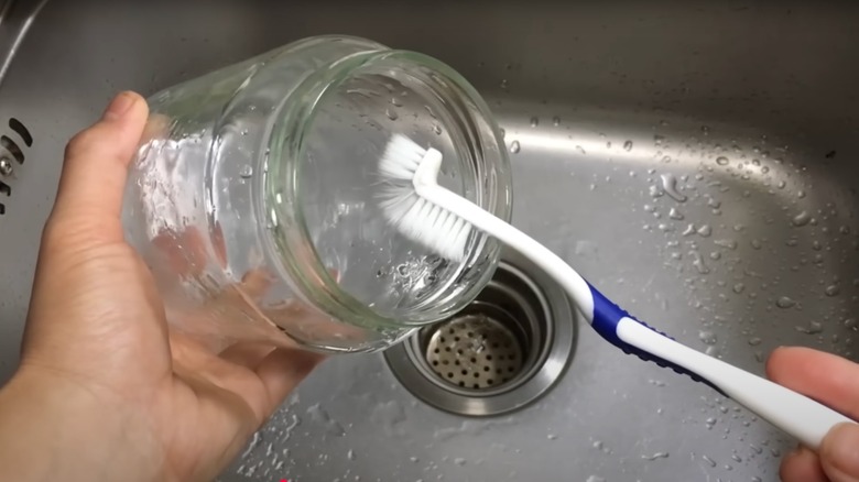 Washing inside of jar with toothbrush