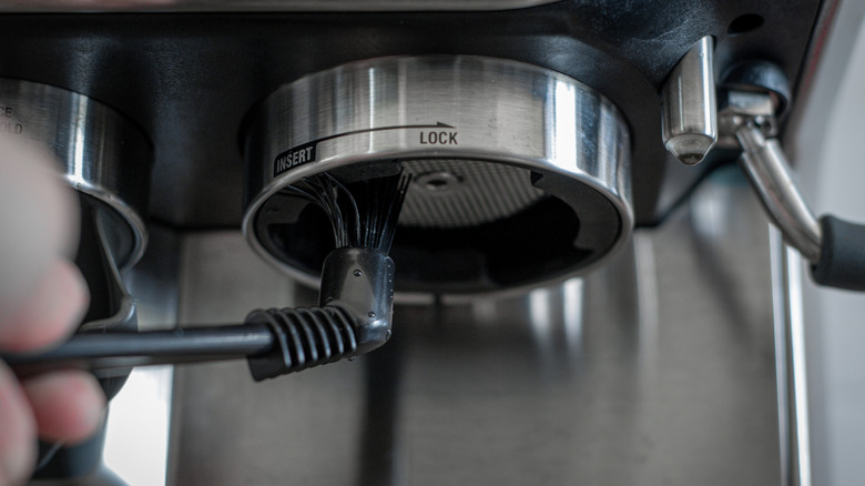 Cleaning espresso machine with brush