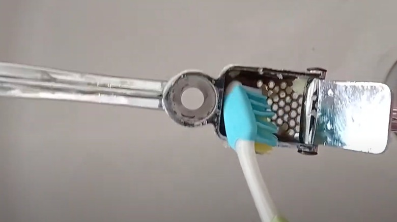 Cleaning garlic press with toothbrush