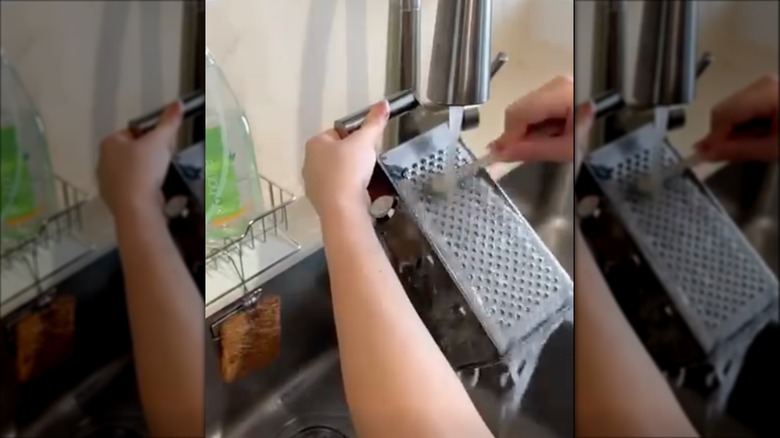 Cleaning cheese grater with a toothbrush