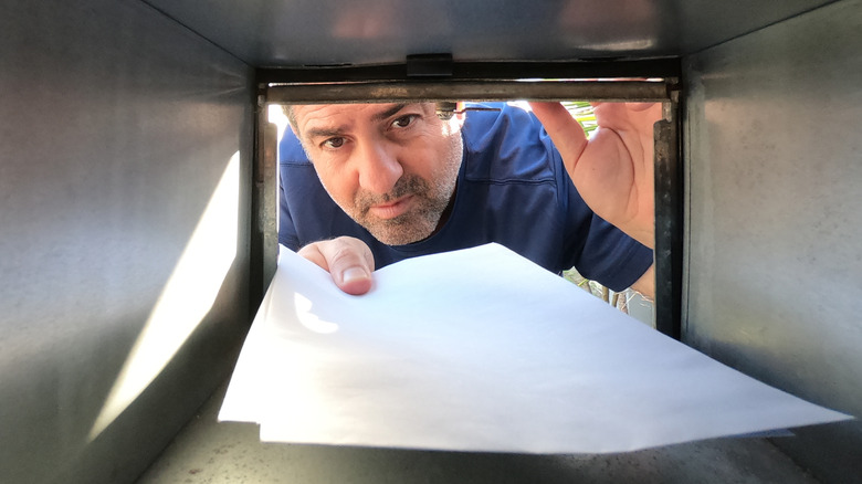 Man looking inside mailbox