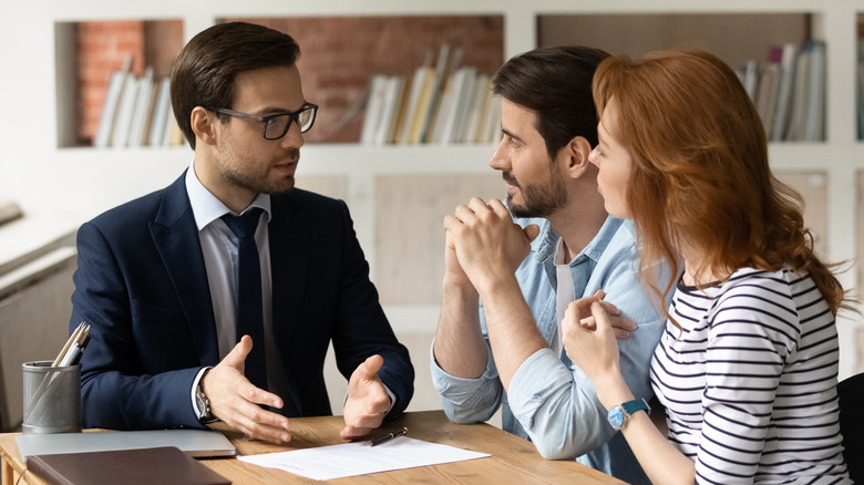 couple talks with real estate agent