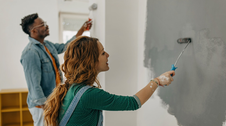 young couple painting a wall