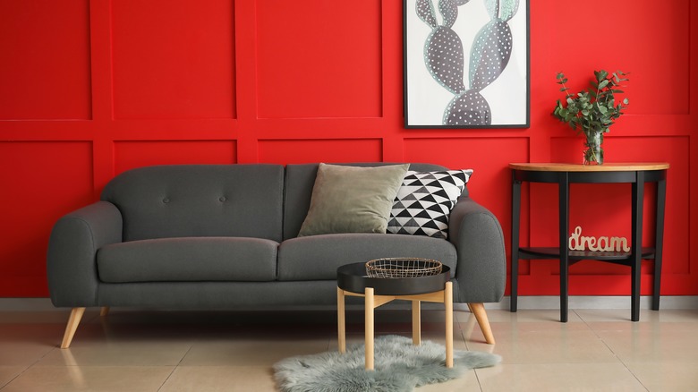 Gray couch with bright red wall
