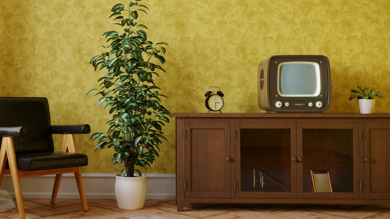 A vintage living room with a small tv set sitting on a cabinet