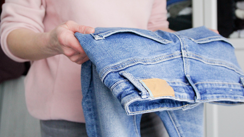Someone holding a pair of jeans