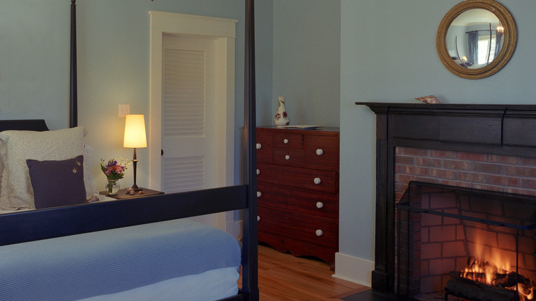 A room in a historic home with a tiny built-in closet painted white.