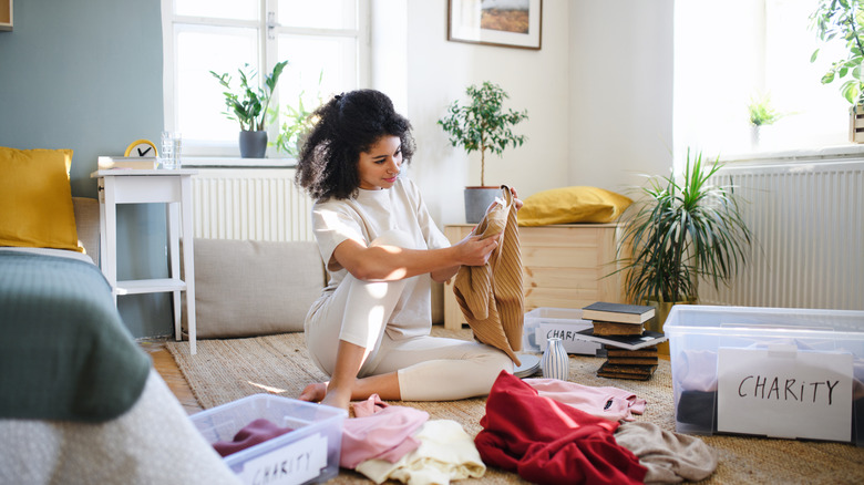 woman sorting clothes to declutter and donate.