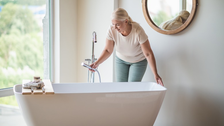 woman filling bathtub with water