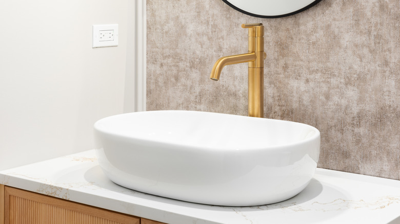 white bathroom vessel sink with gold faucet